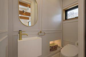 a bathroom with a toilet and a mirror at Kogane Hills Niseko in Rankoshi +54 photos