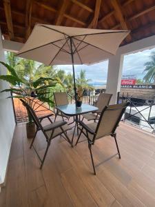 a table and chairs with an umbrella on a deck at Bungalows Garza Blanca a Pie de Playa in San Blas