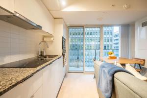 une cuisine avec un évier, un canapé et une table dans l'établissement Stylish Stay with City Views, Pool and Gym, à Toronto