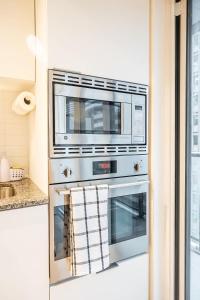 - un four micro-ondes installé au-dessus d'un four dans la cuisine dans l'établissement Stylish Stay with City Views, Pool and Gym, à Toronto 24 autres photos