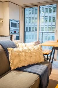 un canapé avec des coussins dessus dans un salon dans l'établissement Stylish Stay with City Views, Pool and Gym, à Toronto