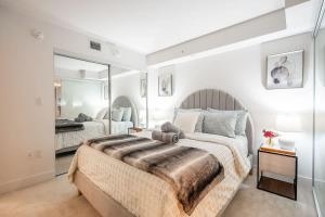 une chambre avec un grand lit et un miroir dans l'établissement Stylish Stay with City Views, Pool and Gym, à Toronto