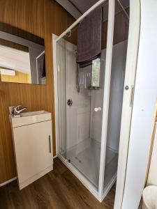 a shower with a glass door in a bathroom at JJJ's Ranch Farm 1 by Tiny Away in Koolboo