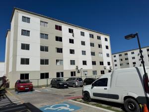 a white van parked in a parking lot in front of a building at Apartamento Térreo Completo! Com Ótima Localização in Fortaleza