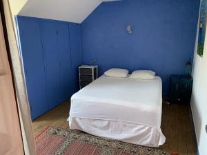a blue bedroom with a white bed and a blue wall at Charmante maison au Croisic avec véranda et jardin pour 4 personnes, chiens acceptés - FR-1-843-20 in Le Croisic