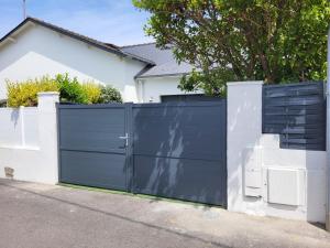 a black gate in front of a house at Le Croisic : Maison 4-6 Pers Climatisée avec Terrasse - FR-1-843-7 in Le Croisic