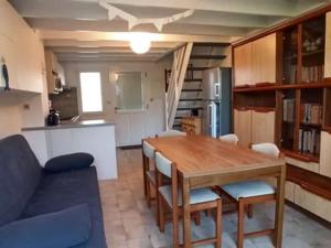 a kitchen and dining room with a wooden table and chairs at Maison proche plages Le Croisic, parking inclus - FR-1-843-14 in Le Croisic
