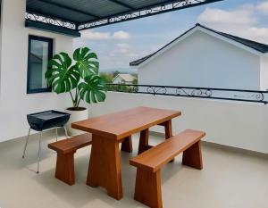 a wooden table and bench on a balcony at Quỳnh An Home in Da Lat