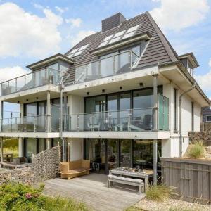 a large house with a balcony and a bench at Lands-End in Hörnum