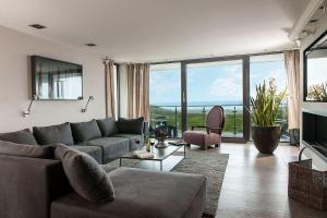 a living room with a couch and a large window at Lands-End in Hörnum