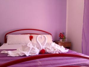 ein Bett mit zwei weißen Schwänen in Weiß in der Unterkunft Appartamenti Abbaidda 2 in Valledoria