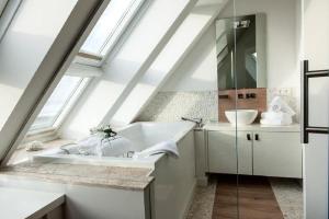 a bathroom with a sink and a bath tub at Lands-End in Hörnum +17 photos