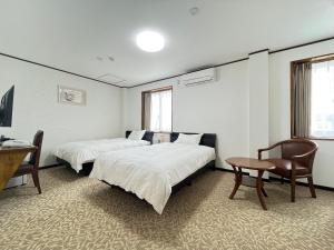 a room with two beds and a table and a desk at Z hotel in Ueda +29 photos