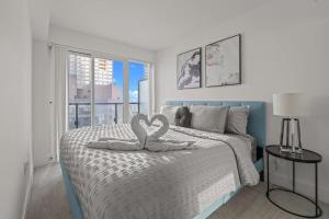 - une chambre avec 2 serviettes en forme de cœur sur un lit dans l'établissement Enjoy the City Skyline View with Pool & Gym, à Toronto