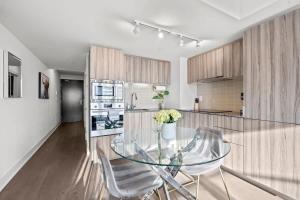 une cuisine avec une table en verre et deux chaises dans l'établissement Enjoy the City Skyline View with Pool & Gym, à Toronto