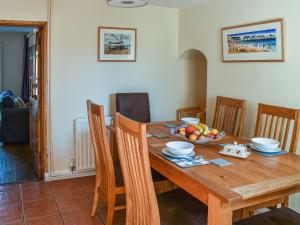 einen Esstisch mit einer Obstschale darauf in der Unterkunft Pakefield Seaview Cottage in Lowestoft