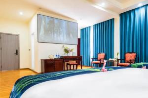 a large screen in a hotel room with a bed at Feng Hui Snow Mountain Resort Hotel Deqin Feilai Temple Branch in Shengping