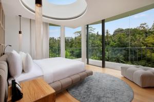 a bedroom with a bed and a large window at Bumi Kinar Skylight in Ubud +99 photos