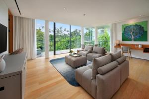 a living room with two couches and a table at Bumi Kinar Skylight in Ubud