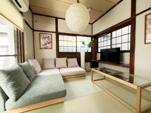 a living room with a couch and a tv at 弥生町1丁目戸建 in Tokyo
