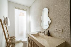 a bathroom with a sink and a mirror at Villa Estrella Seseh in Cemagi