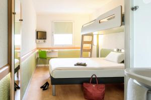 una camera d'albergo con letto e lavandino di ibis budget Duisburg City am Innenhafen a Duisburg