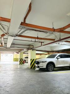 Ein weißes Auto, das in einer Parkgarage geparkt ist in der Unterkunft Pacific Park Hotel in Manila