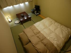 
a bedroom with a bed and a lamp at Kyoto Hana Hostel in Kyoto
