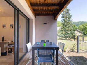 eine Terrasse mit Tisch und Stühlen auf einem Balkon in der Unterkunft Appartement 5 personnes avec Wifi, parking, proche du lac à Génos - FR-1-695-78 in Génos