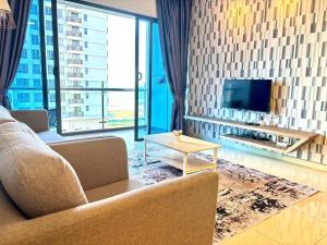 een woonkamer met een bank, een tv en een tafel bij Atlantis Residence Malacca by Mannisstay in Melaka