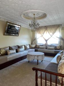 a living room with a couch and a chandelier at Apparemment al baraka in Tangier