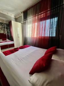 a large bed with red pillows in a bedroom at Apparemment al baraka in Tangier