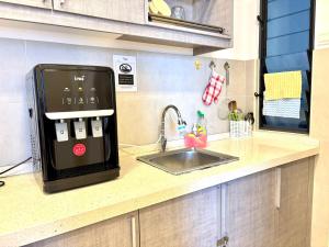 een aanrecht met een spoelbak en een magnetron bij Atlantis Residence Malacca by Mannisstay in Melaka