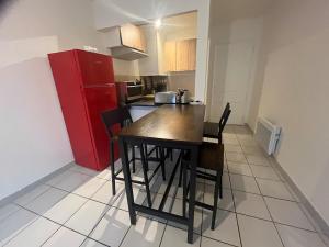 a kitchen with a table and chairs and a red refrigerator at Salon de Provence in Salon-de-Provence