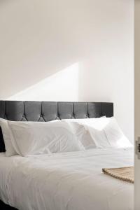 吉斯伯恩Fresh 1BR Apt Middle of CBD的一张带黑色床头板和白色枕头的白色床