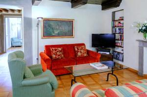 フィレンツェにあるCorno Florentine Apartment by 360Rentalsのリビングルーム(赤いソファ、テレビ付)