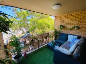 a patio with a blue couch on a balcony at Nico's unit Two bedrooms shared in Sydney