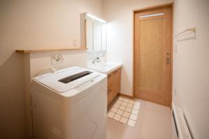 a small bathroom with a washing machine and a sink at 冬のソナタ2 in Nakafurano
