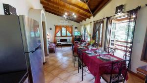 a dining room with tables and chairs and a refrigerator at Quinta Teca at Opera Salvaje in Playa Hermosa