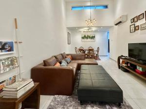 a living room with a brown couch and a television at Melodies Moderne 2B2B Near HolidayPlaza KSL in Johor Bahru