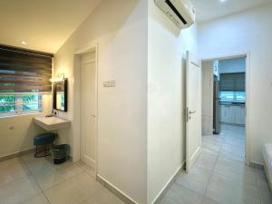 a hallway with a bathroom with a sink and a mirror at Melodies Moderne 2B2B Near HolidayPlaza KSL in Johor Bahru