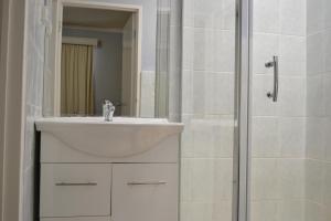 奧克利的住宿－查斯頓行政汽車旅館，白色的浴室设有水槽和淋浴。