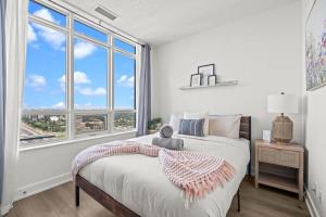 une chambre avec un lit et une grande fenêtre dans l'établissement 2BR Penthouse Views of Toronto, Pool and Sauna, à Toronto