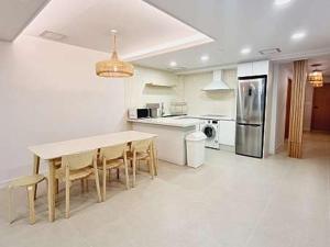 a kitchen with a table and chairs and a refrigerator at Busan Gwangan 273 in Millak-tong