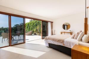 a bedroom with a bed and sliding glass doors at IBU The Sanctuary by OXO in Ubud +24 photos