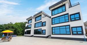 ein großes weißes Gebäude mit blauen Fenstern in der Unterkunft Ongjin Guardians Pool Villa in Sojang-gol