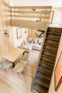Un escalier mène à un salon avec une table et des chaises. dans l'établissement Ma Montagne Chic 4, à La Bresse