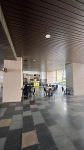 une pièce vide avec des tables et des chaises dans un bâtiment dans l'établissement Mutiara Bali Residence Melaka, à Malacca