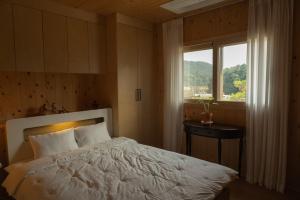 Ένα ή περισσότερα κρεβάτια σε δωμάτιο στο Cheonan Stay Daejeong Lake