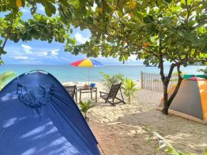 a tent and a table on the beach at Aloha Ocean View Resort in Pandan